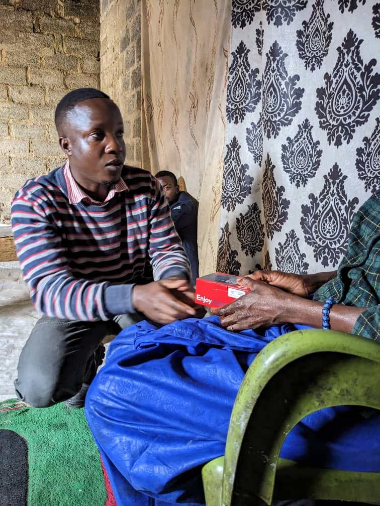 Caristo handing over a donated phone to a beneficiary during a Sharing Cohorts Foundation outreach